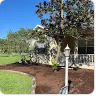 Project photo from a Google review showing fresh mulch beds and cleaned-up landscaping.
